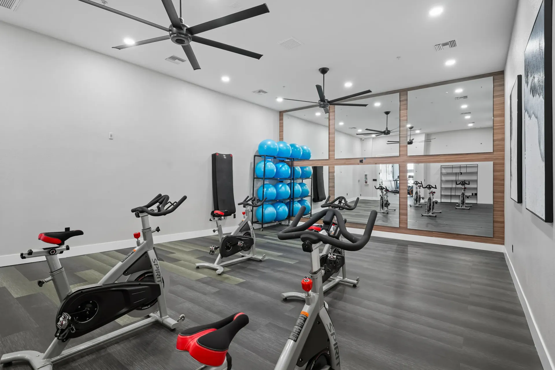 Spin bikes and exercise equipment in a modern fitness center with large mirrors at Cornerstone Park in Henderson, NV.