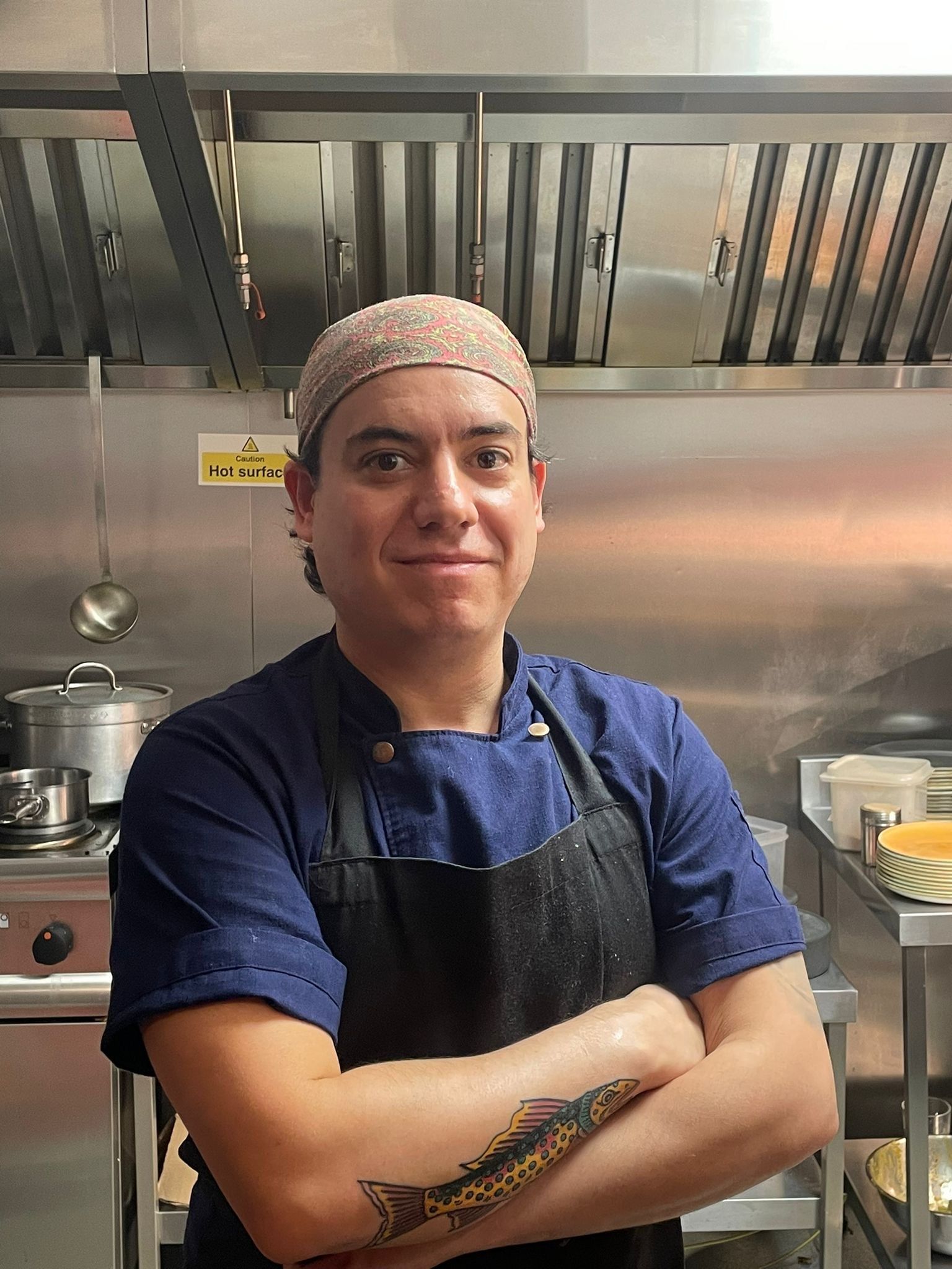 A chef with his arms crossed in a kitchen