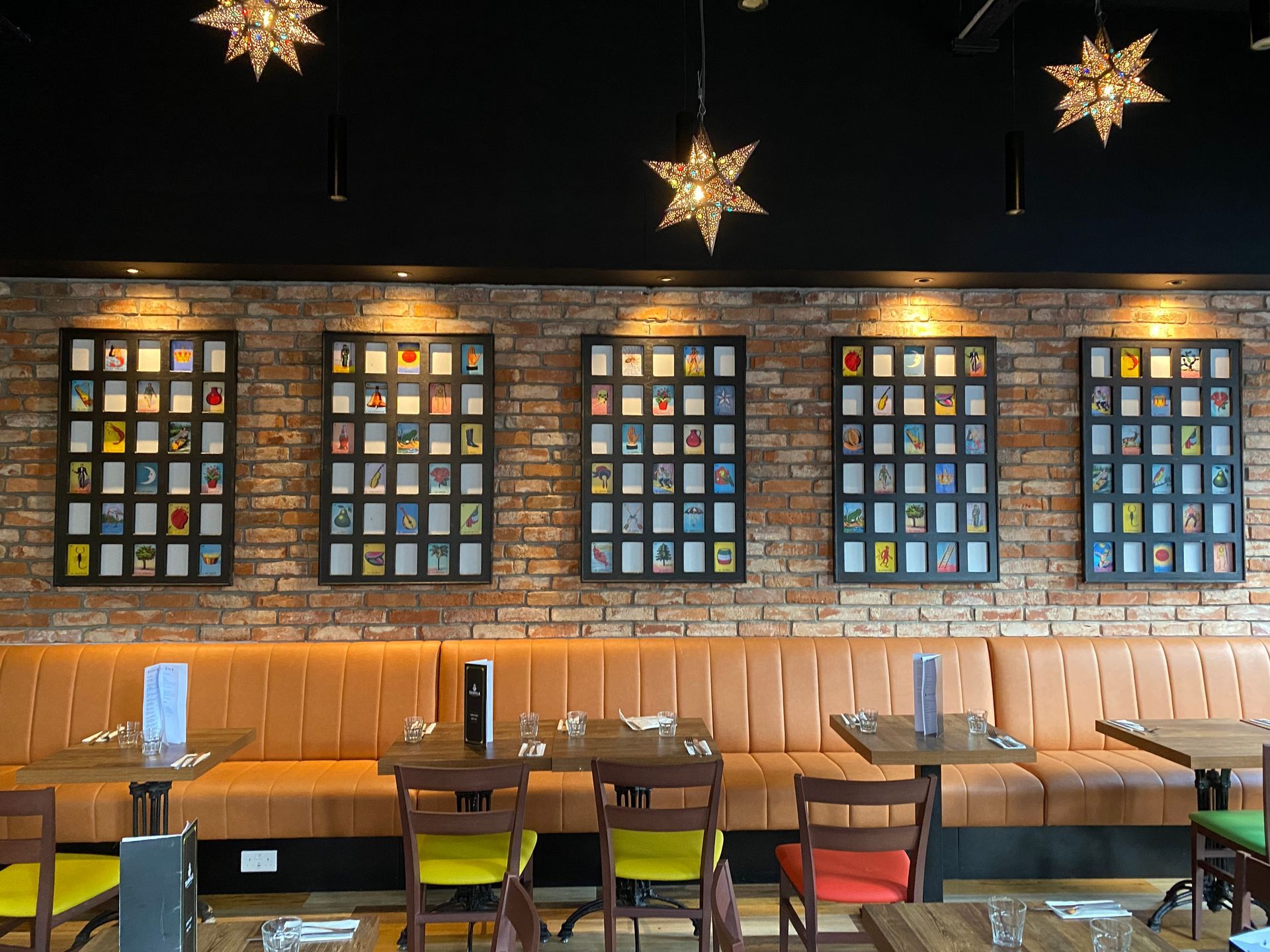 A restaurant with tables and chairs and a brick wall