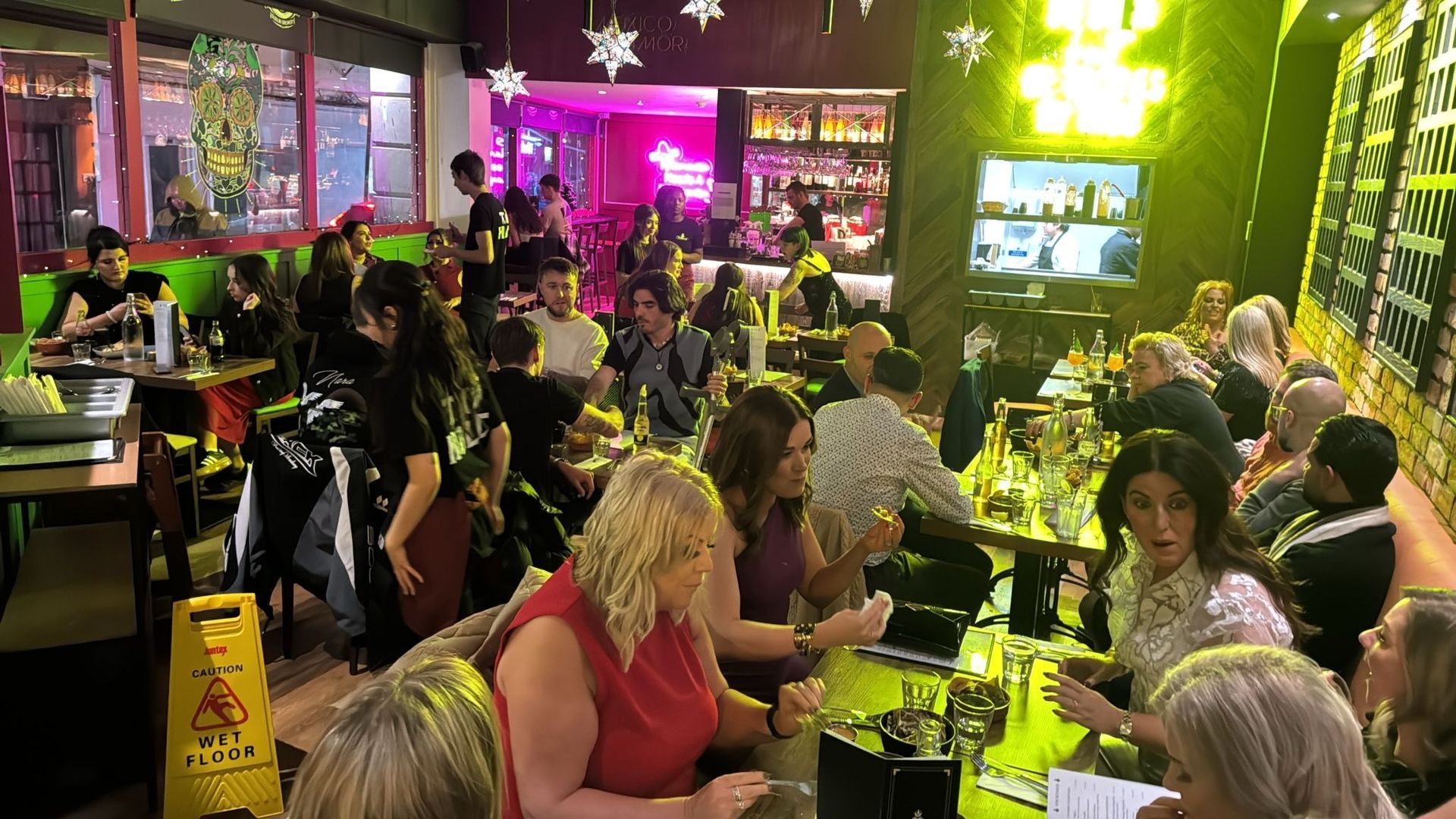 A large group of people are sitting at tables in a restaurant