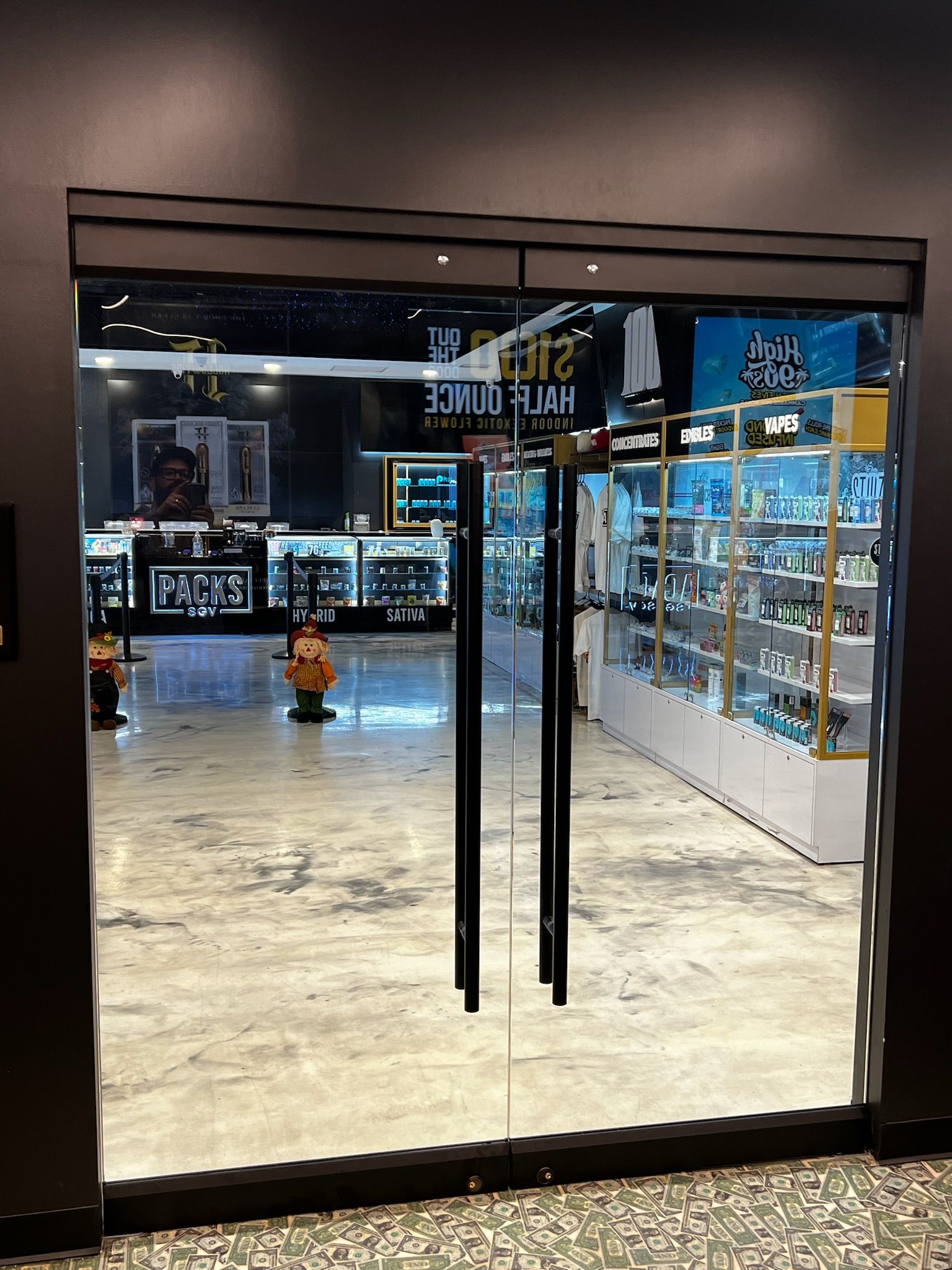 Glass doors leading into a well-lit shop, display cases filled with products,