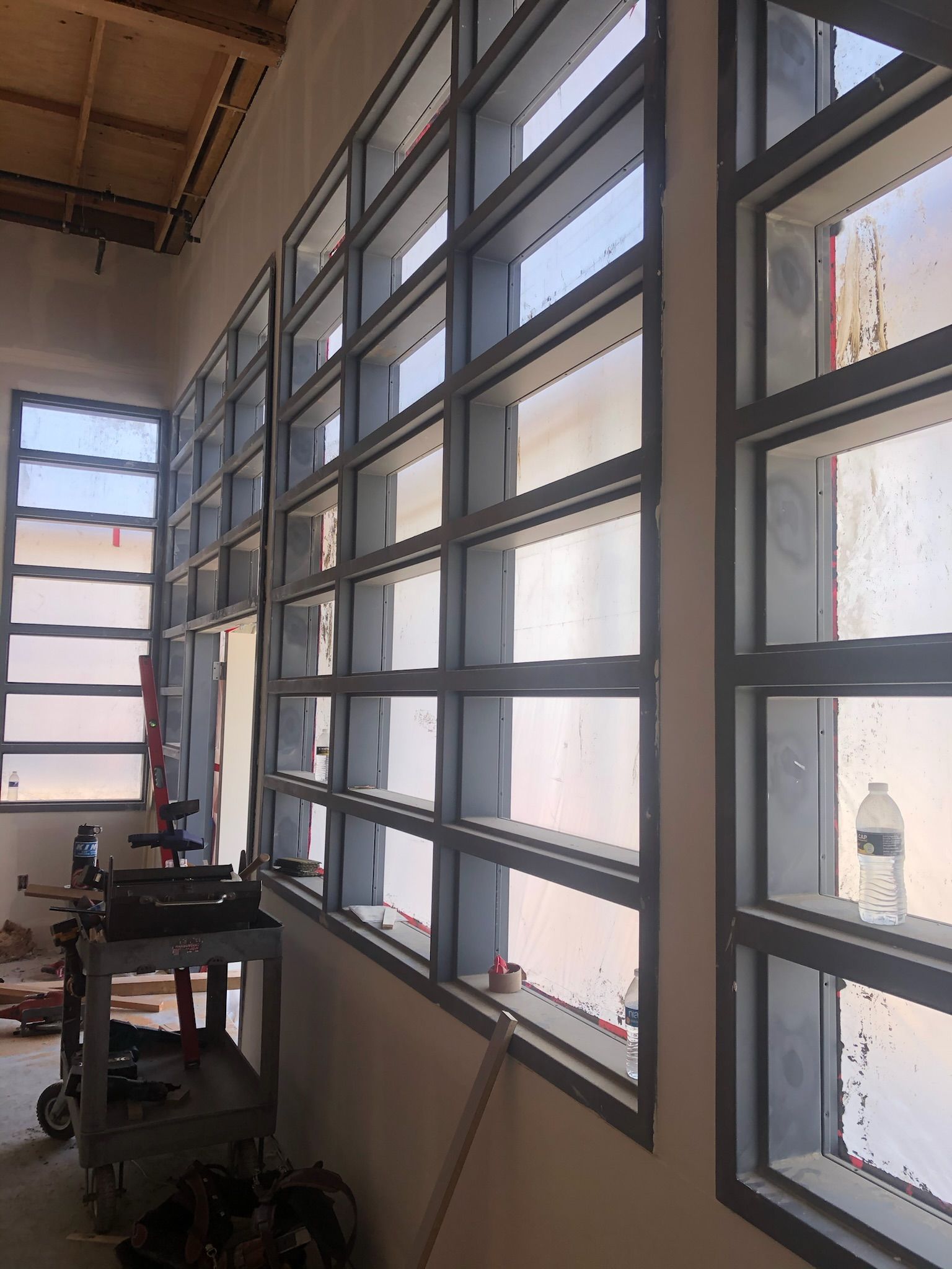 Row of rectangular windows with steel frames, indoors, likely under construction.