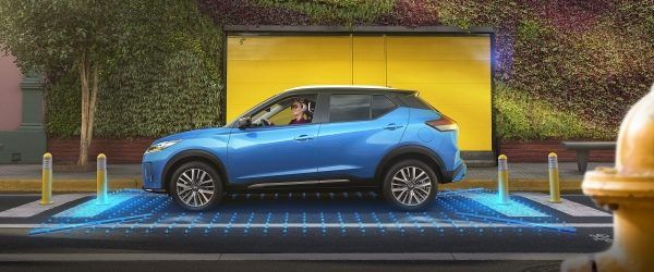 Un SUV azul estacionado sobre una plataforma luminosa frente a una puerta de garaje de color amarillo brillante.