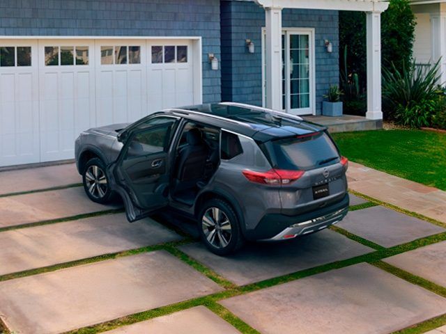SUV gris oscuro estacionado frente a una casa, con la puerta trasera abierta.