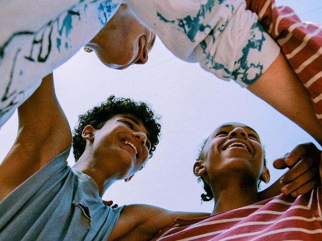 A group of people are standing in a circle looking up at the sky.