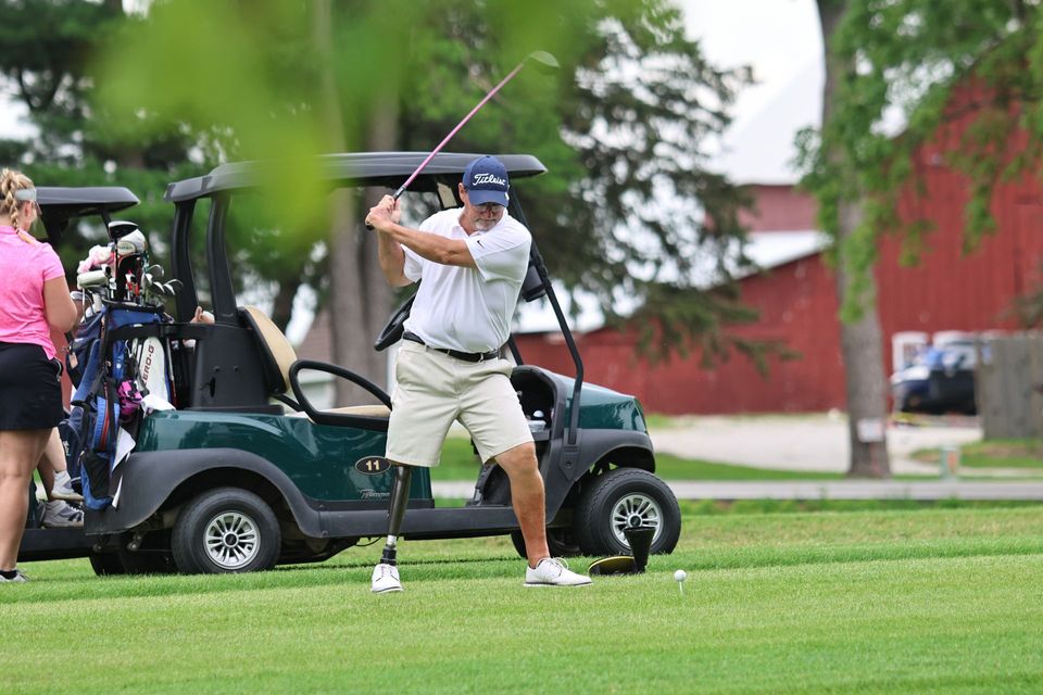 A man is swinging a golf club on a golf course.