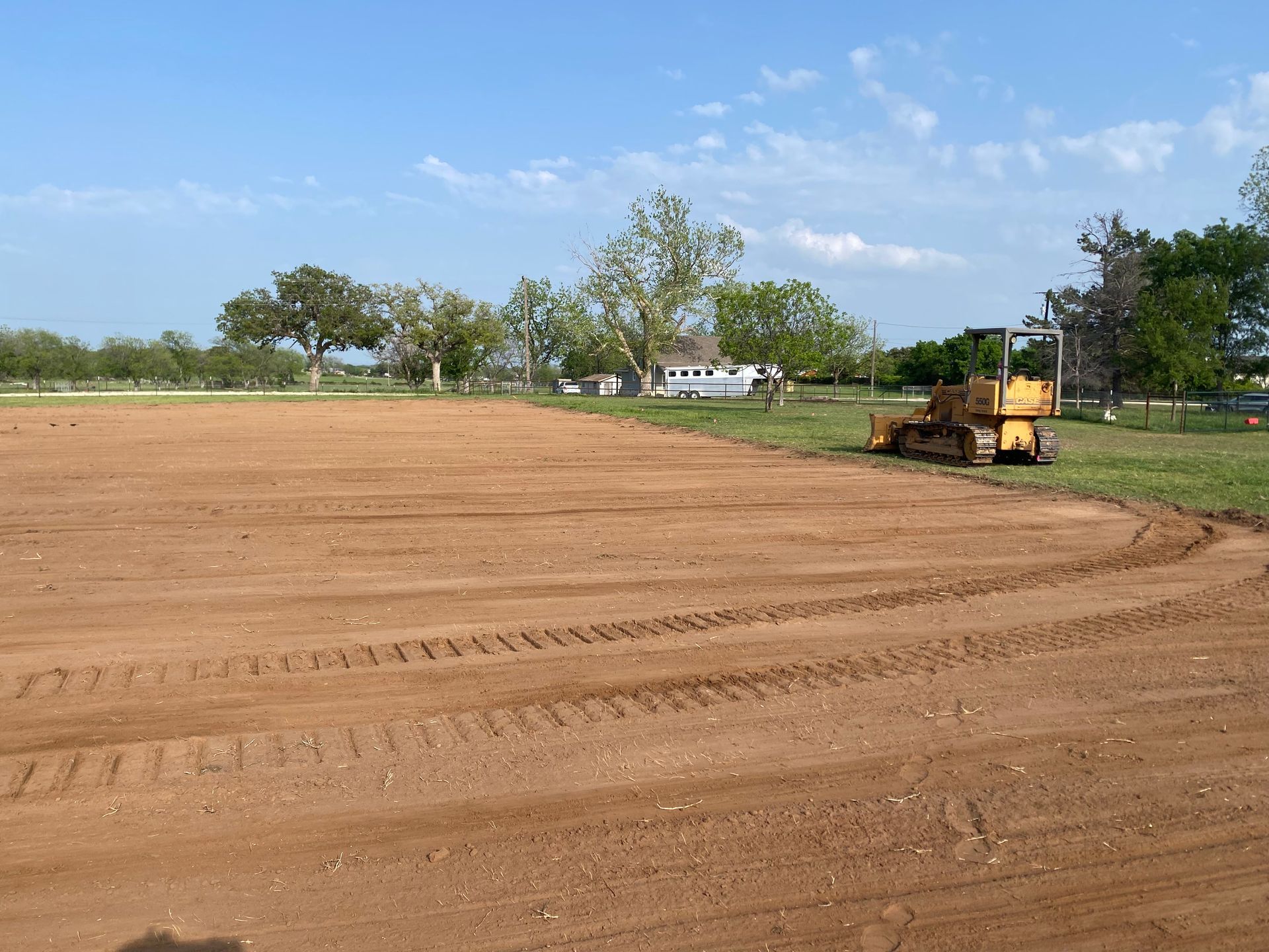 A bulldozer is working on a dirt field