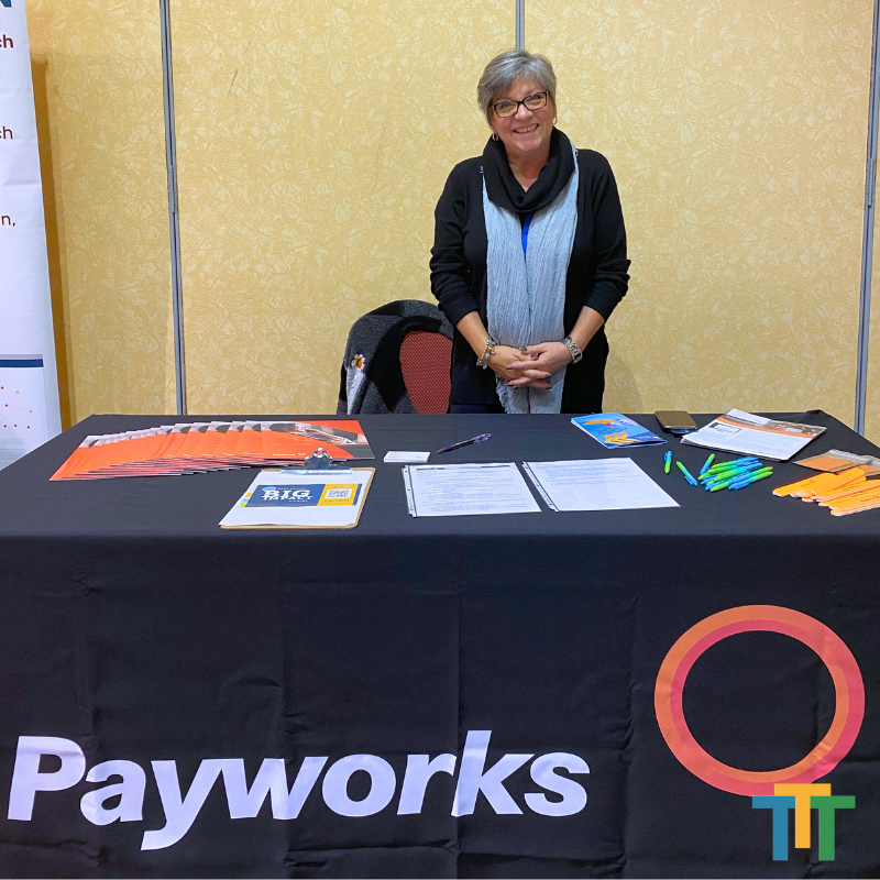 A woman stands behind a payworks table