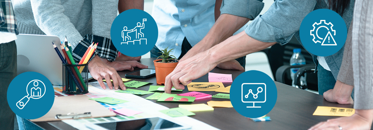 A group of people are sitting around a table with sticky notes on it.