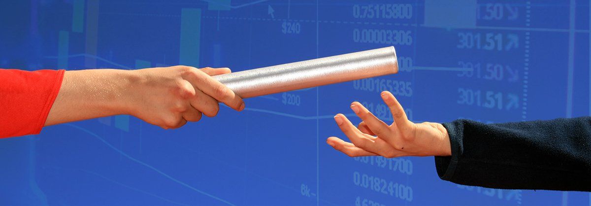 A person is passing a relay baton to another person.