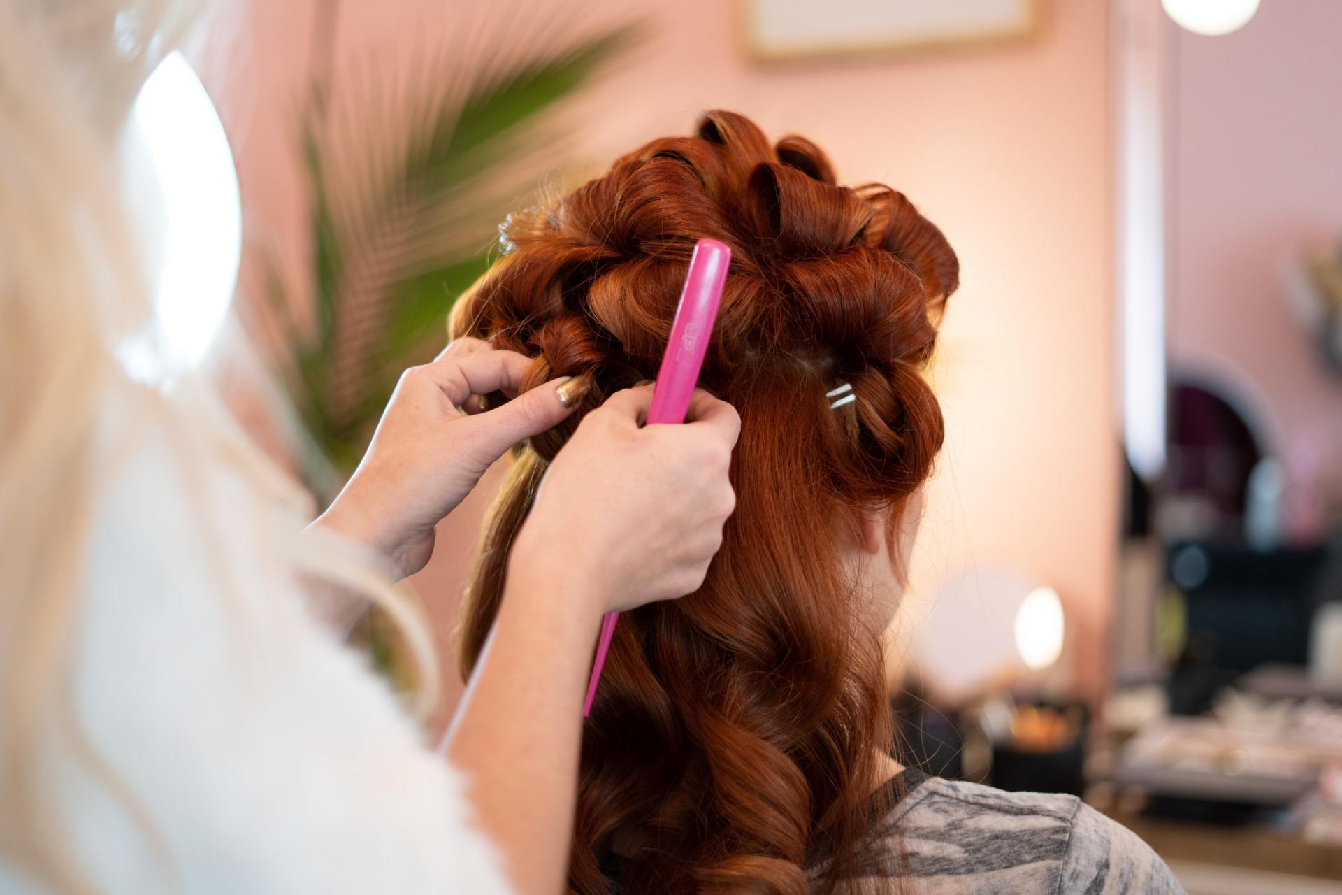Une femme se fait coiffer par un coiffeur dans un salon.