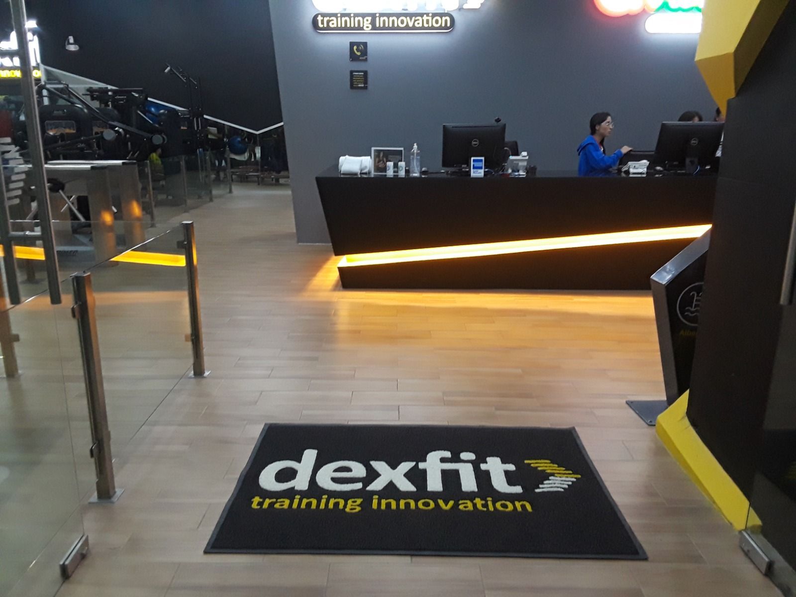 Rincón de oficina con vinilos decorativos motivacionales y una mesa redonda rodeada de sillas.