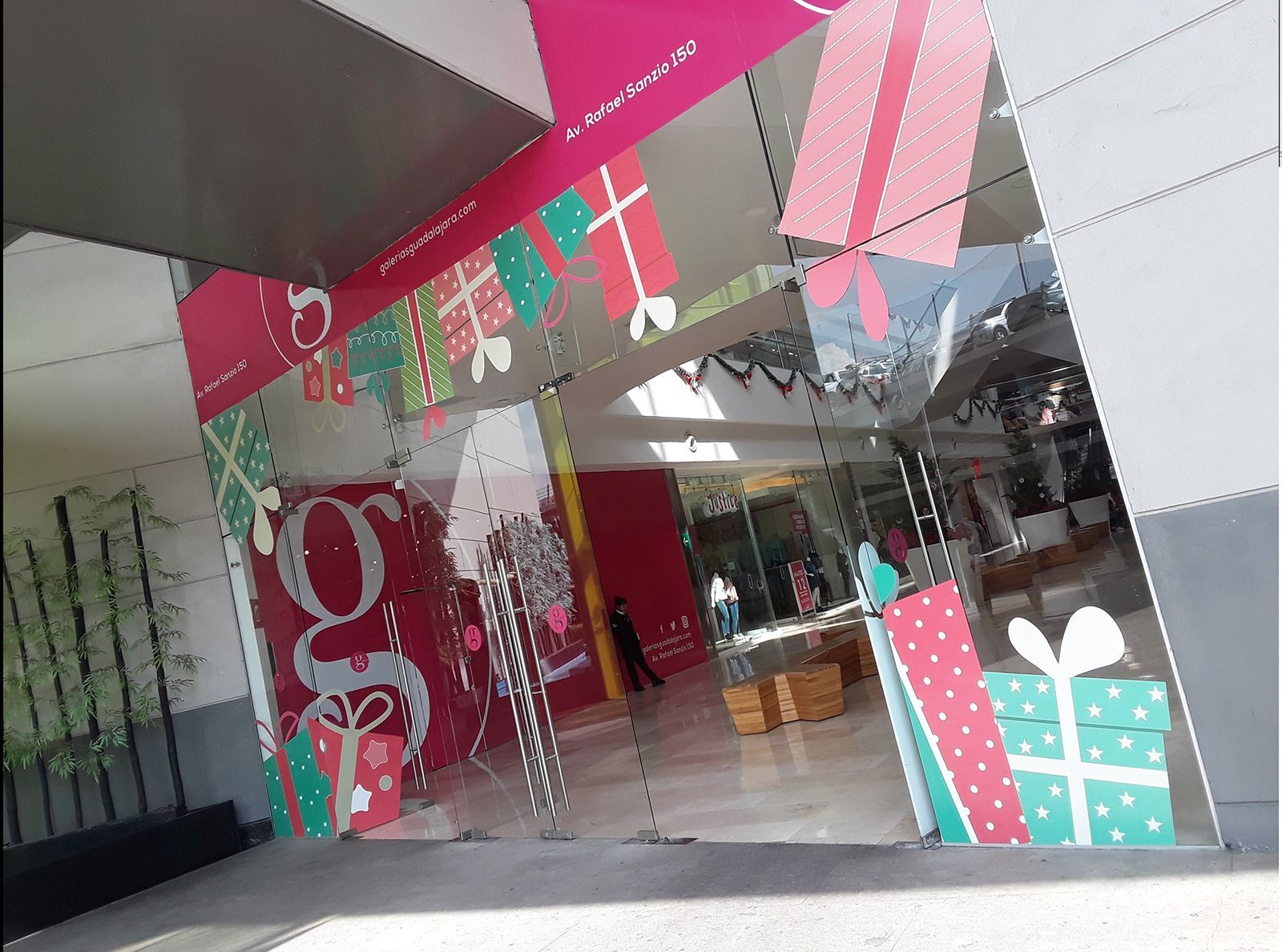 Entrada con decoración navideña. Se ven regalos y la letra 