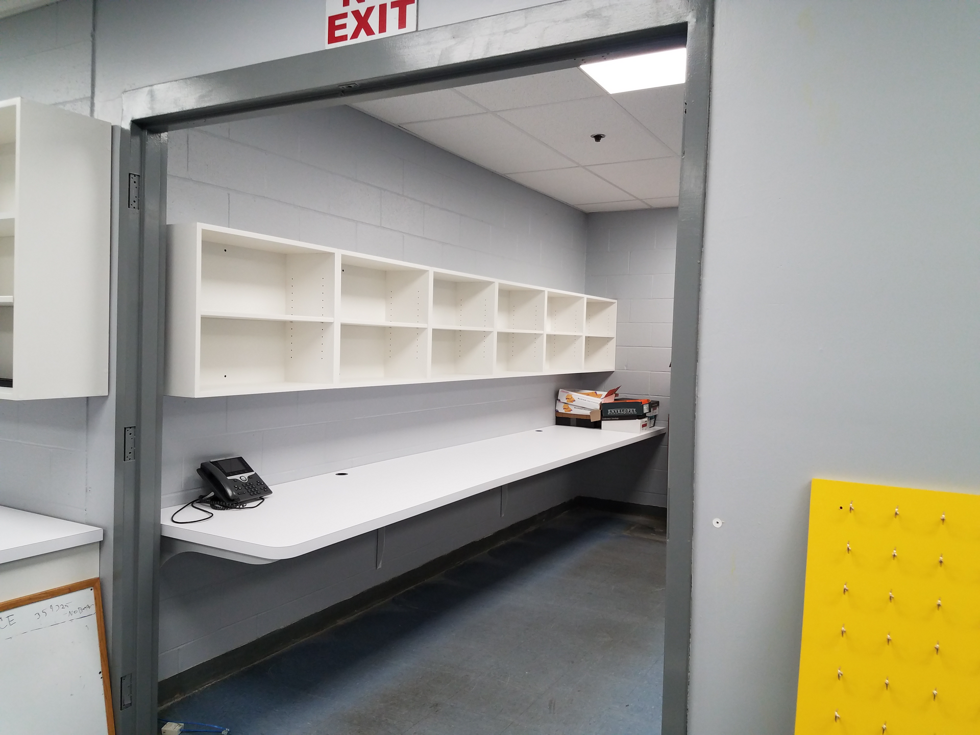 An empty room with a sign that says exit on the wall.