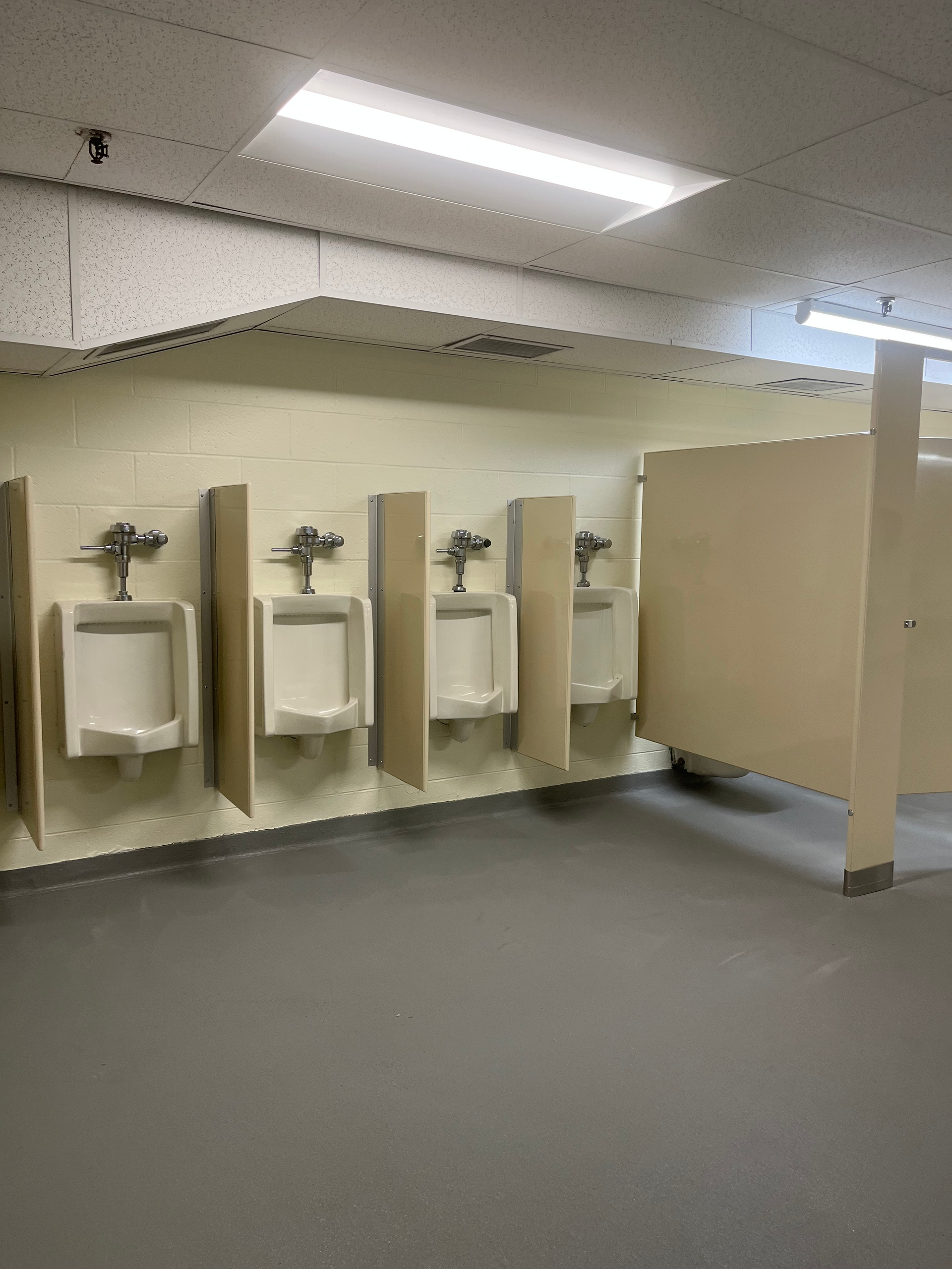 A bathroom with a row of urinals on the wall