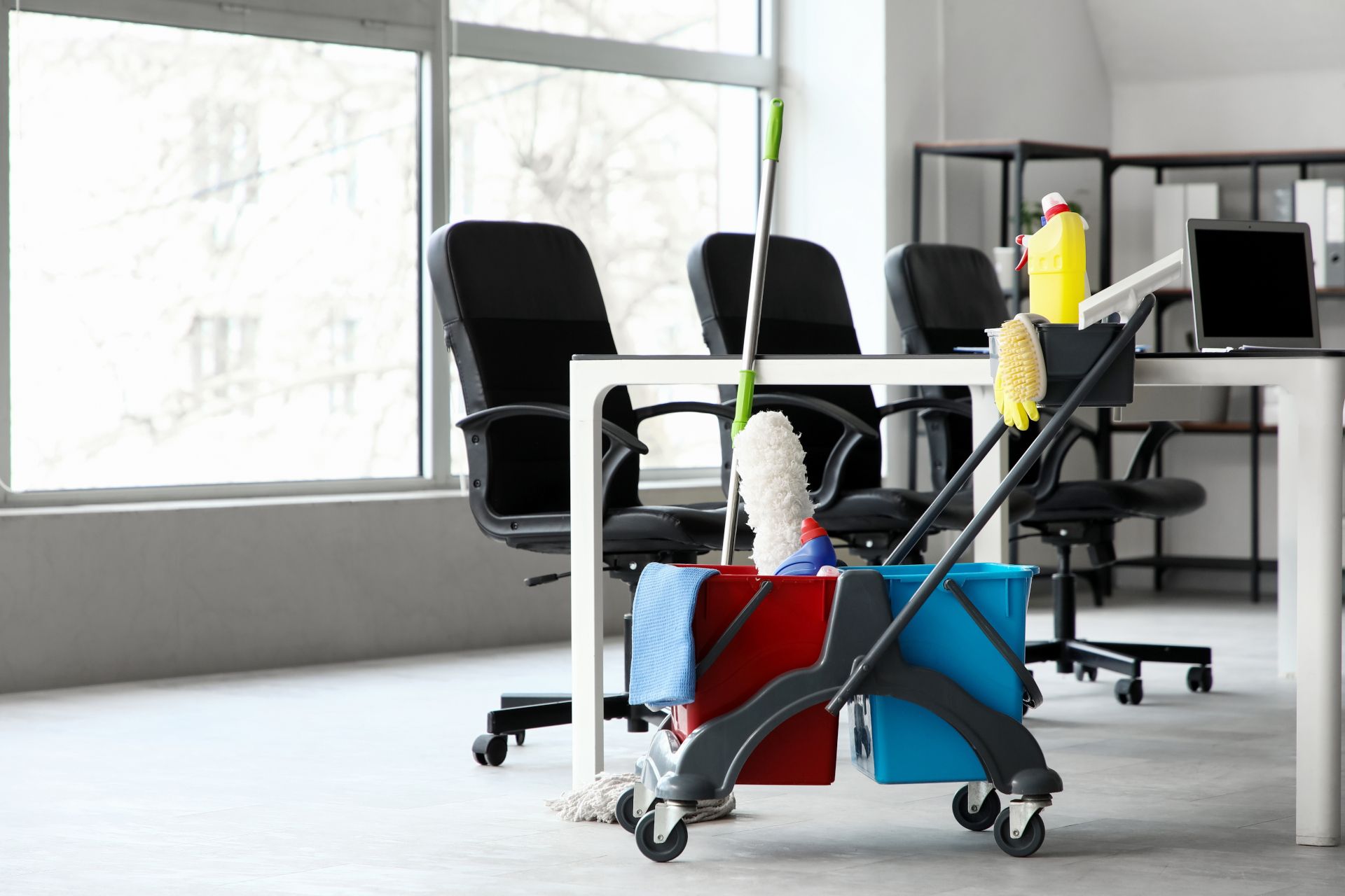Office cleaning cart with buckets and supplies in a modern workspace