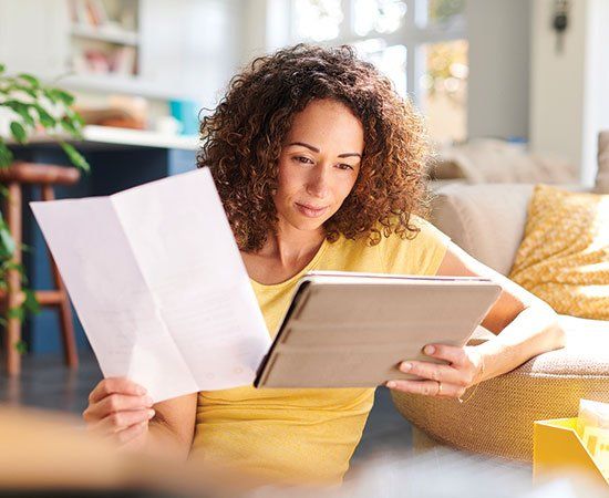 Woman Holding Paper And Gadget — Roseland, NJ — Faloni Law Group, LLC Woman Holding Paper And Gadget — Roseland, NJ — Faloni Law Group, LLC