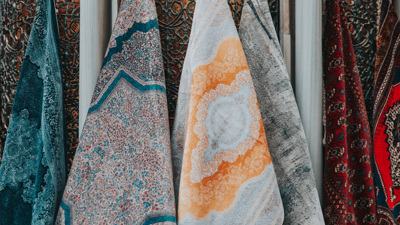 Colorful patterned fabrics hanging for display.
