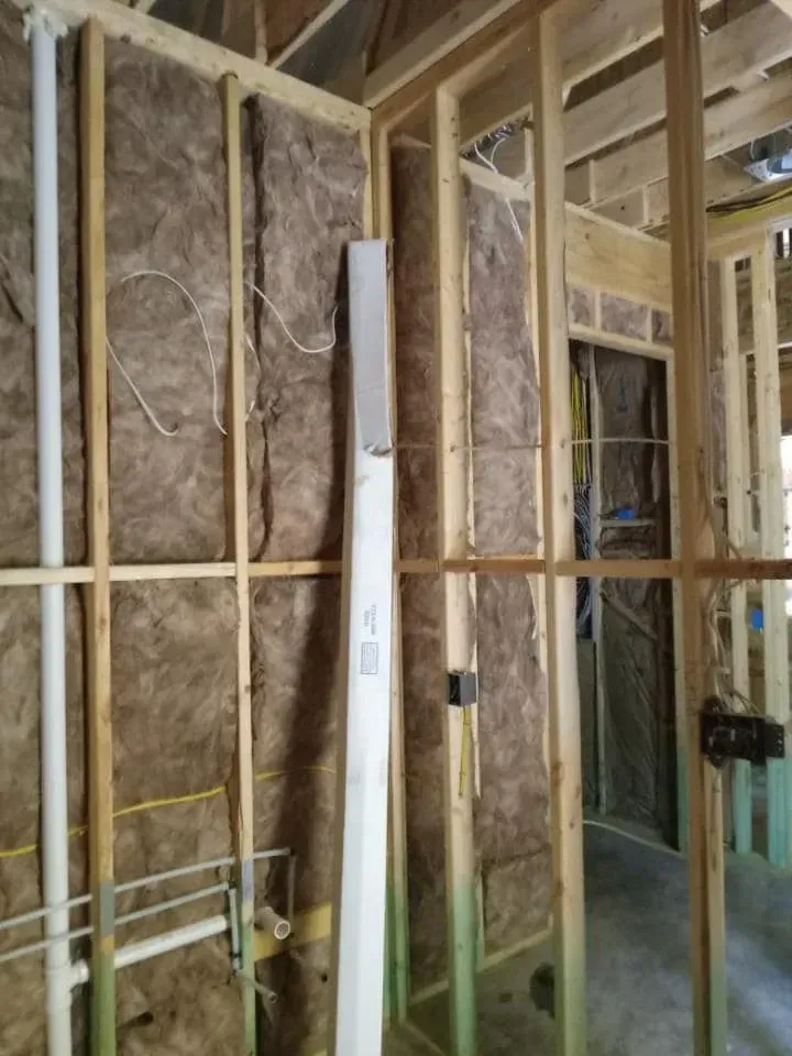 Interior construction with wooden framing and insulation in the walls.