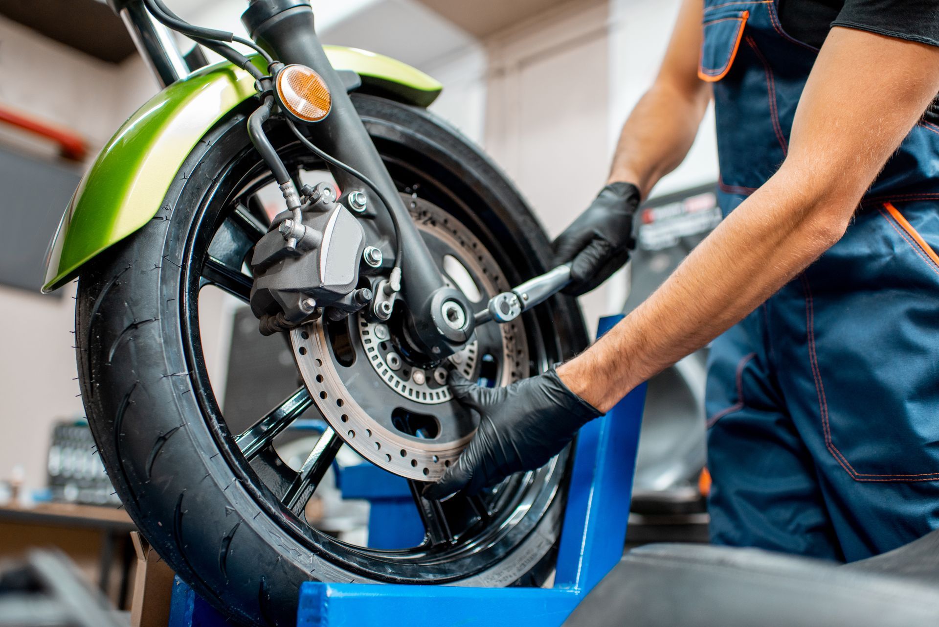 Close-up of a mechanic performing a motorcycle maintenance, at the workshop. Close-up of a mechanic performing a motorcycle maintenance, at the workshop.