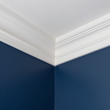 White crown molding meeting a navy blue wall at a corner ceiling edge