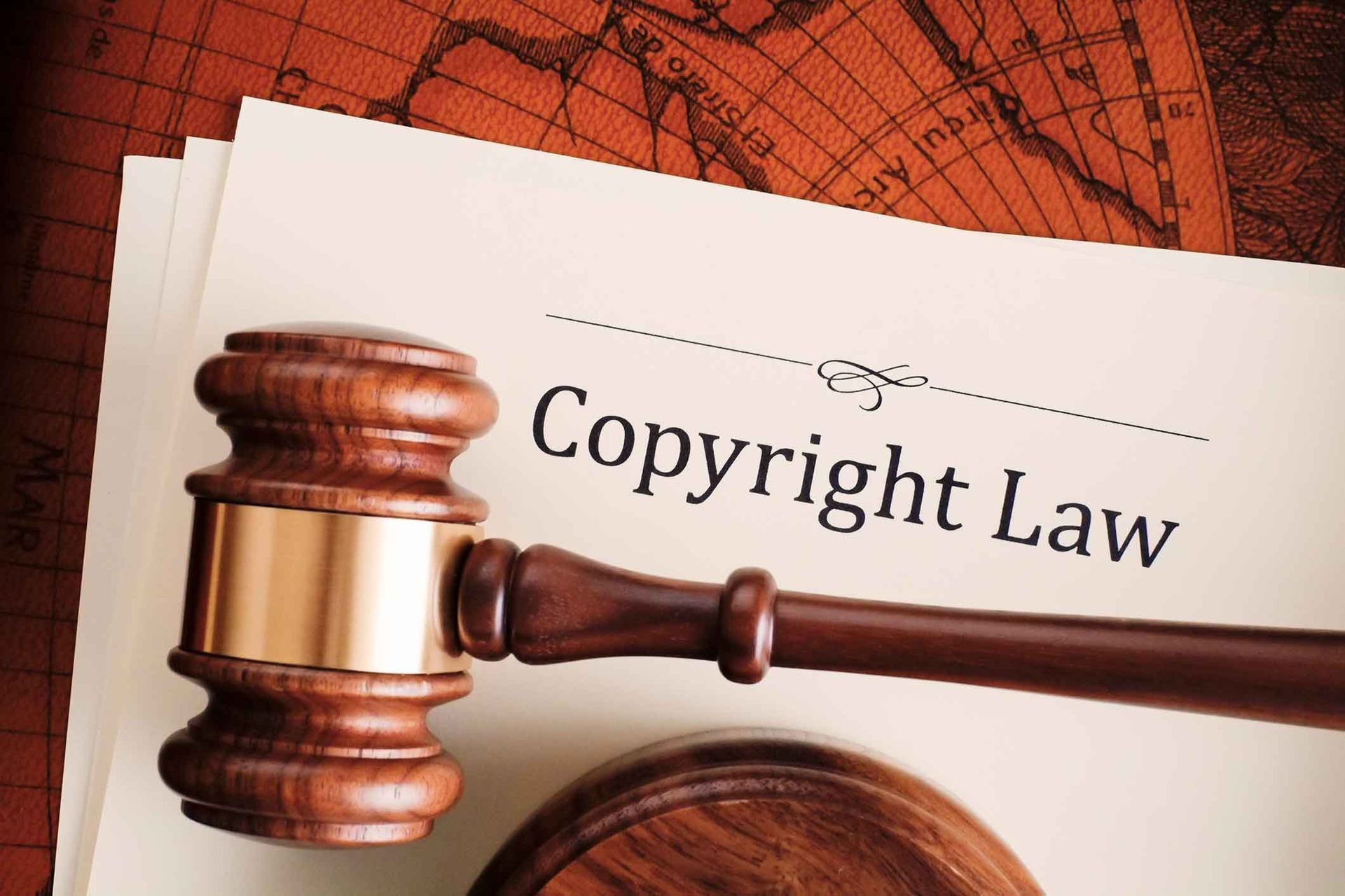 A wooden gavel is sitting on top of a piece of paper that says copyright law