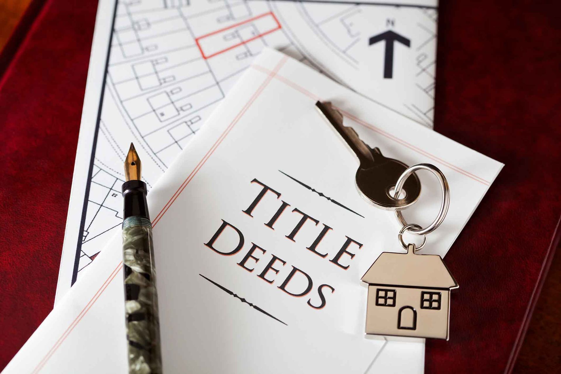 A pen is sitting on top of a piece of paper that says title deeds