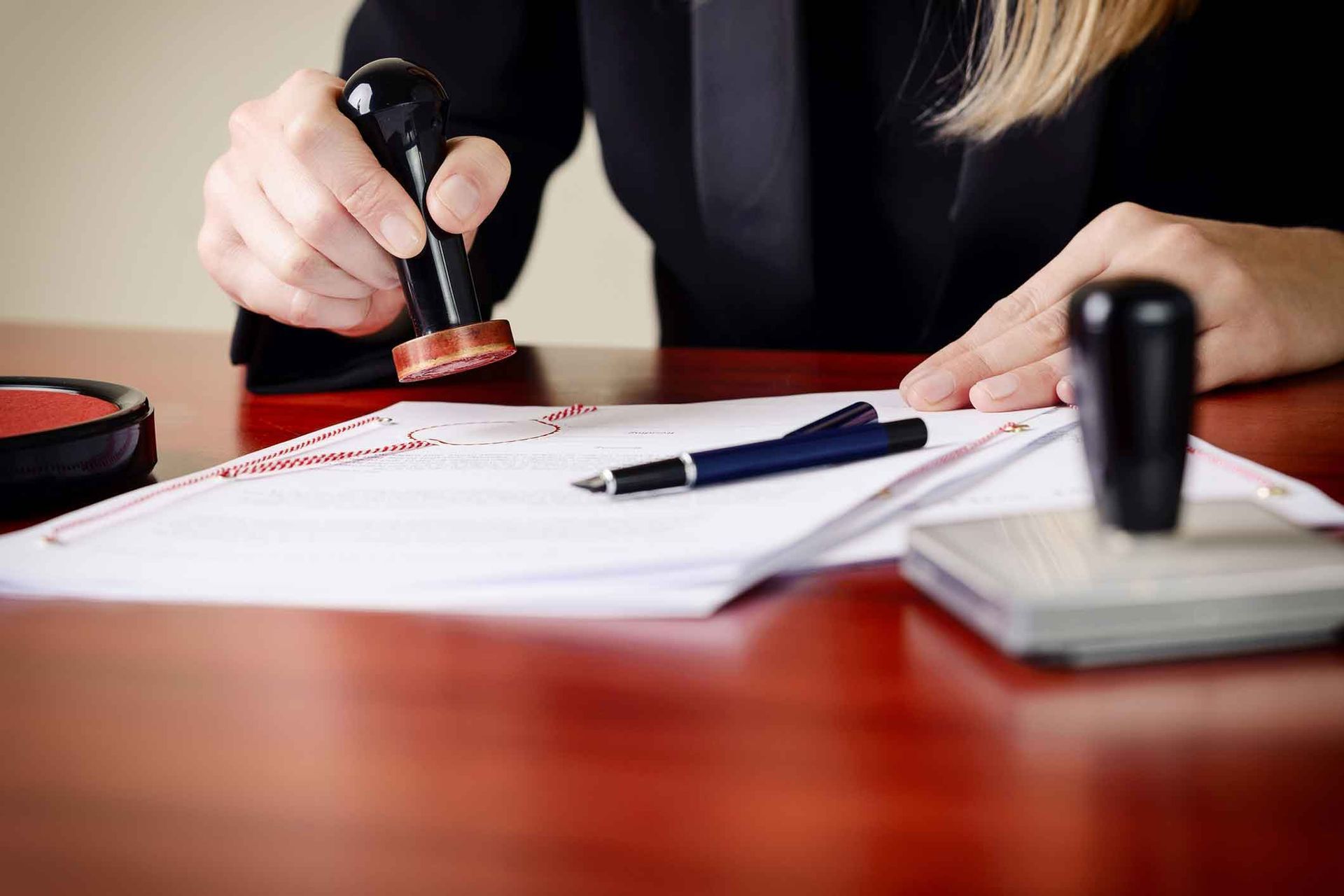 A woman is stamping a document on a table.