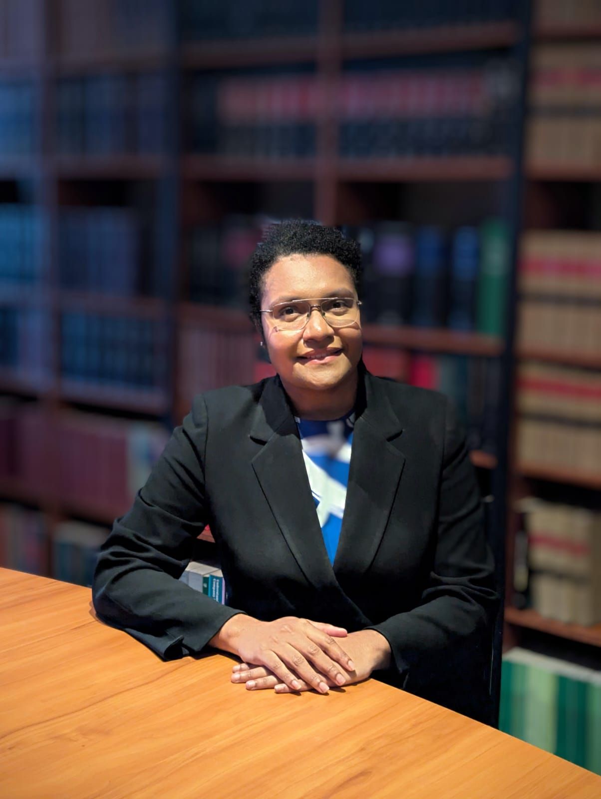 A woman in a black jacket is smiling for the camera