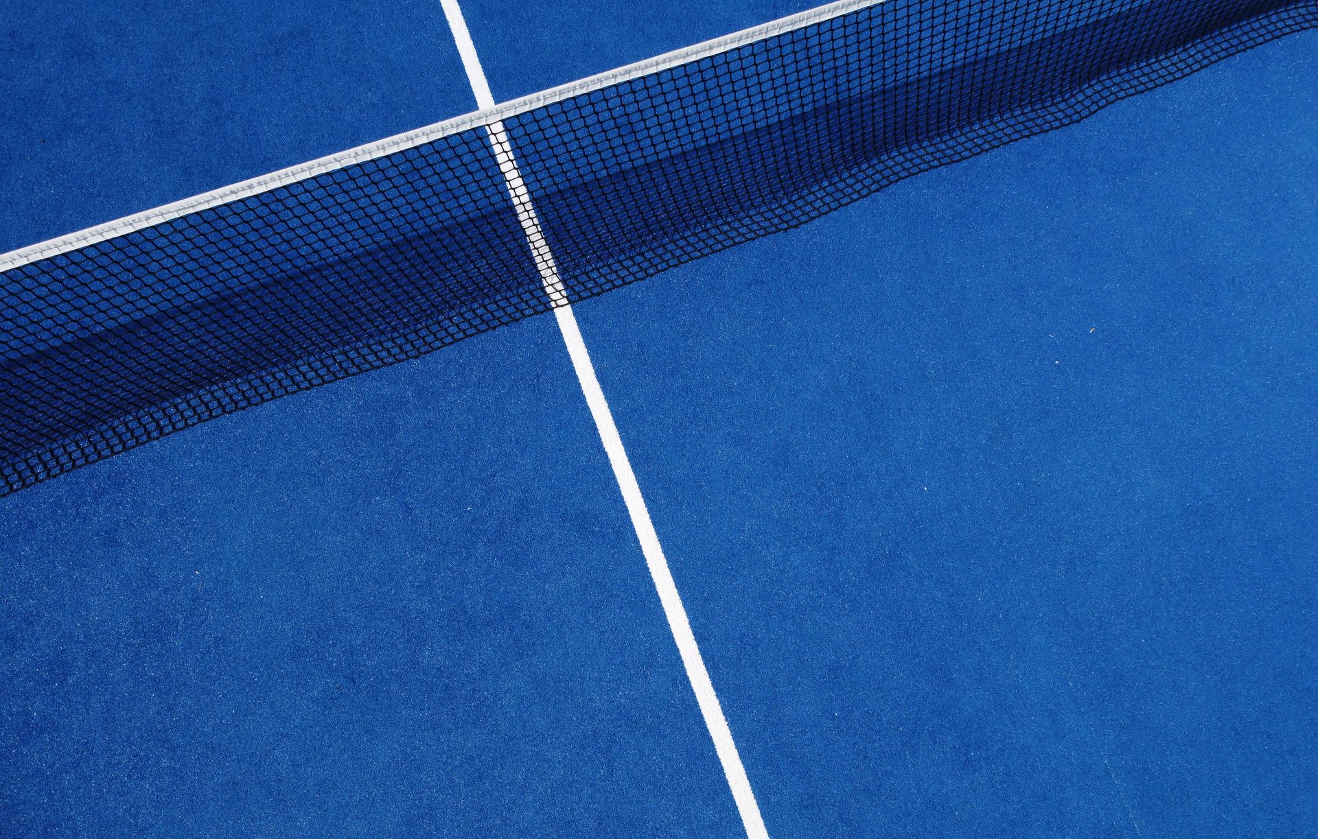 A blue tennis court with white lines and a net