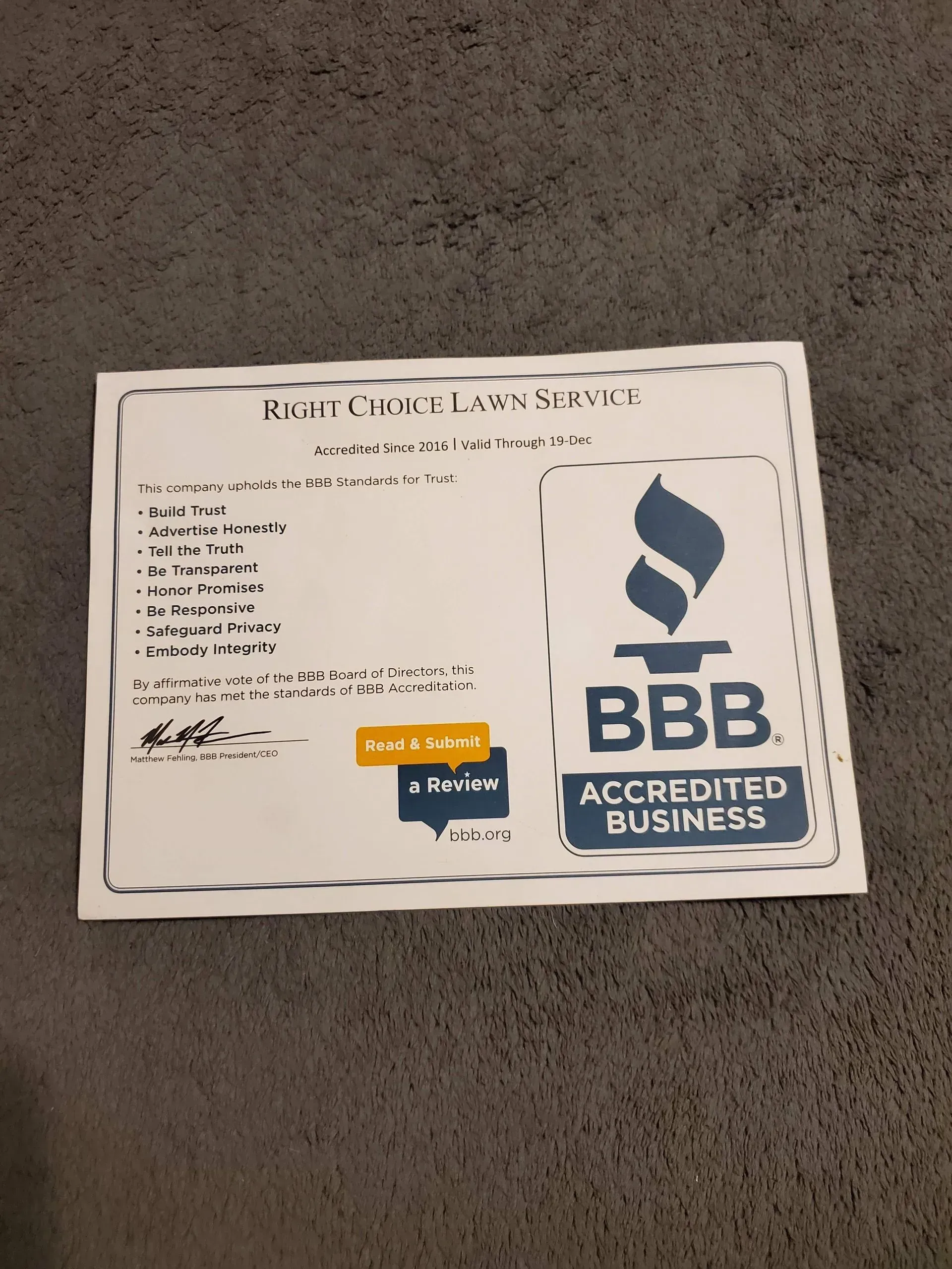 White printed certificate on gray carpet with BBB Accredited Business logo and blue/orange seals