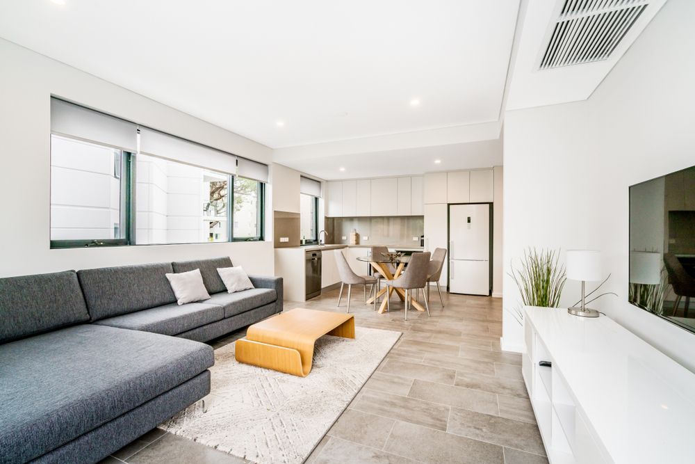 A Living Room With A Couch , Table , And Television — Tamworth Strata Management Services in Scone, NSW