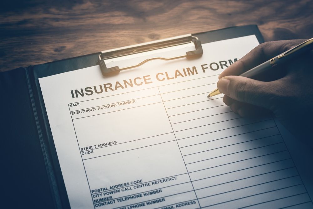 A Person Is Writing On An Insurance Claim Form On A Clipboard — Tamworth Strata Management Services in Moree, NSW