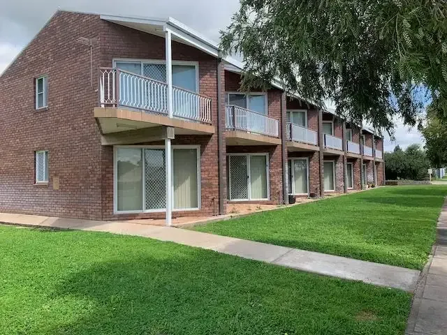A Brick Apartment Building With A Lot Of Windows And Balconies — Tamworth Strata Management Services in Gunnedah, NSW