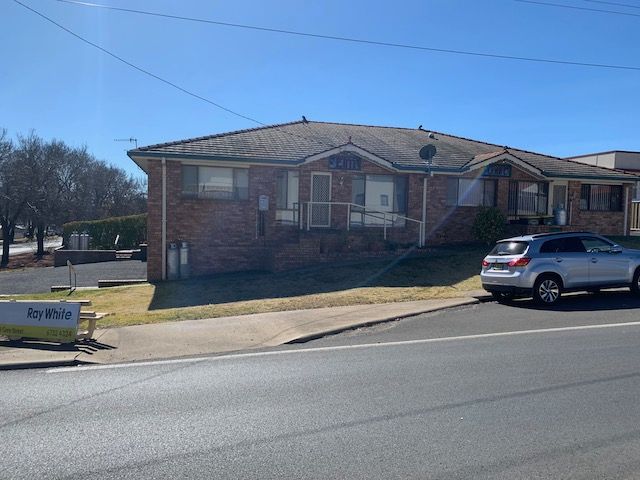 A Brick House With A Driveway Leading To It — Tamworth Strata Management Services in Glen Innes, NSW