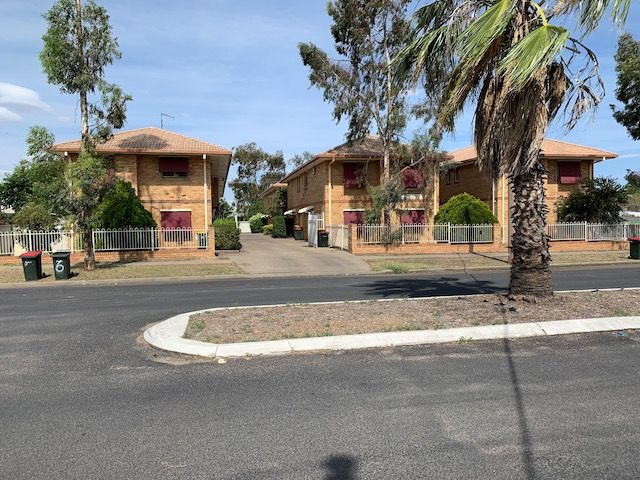 Three brick townhouses with red shutters and matching fences, on a sunny suburban street. — Tamworth Strata Management Services in Moree, NSW