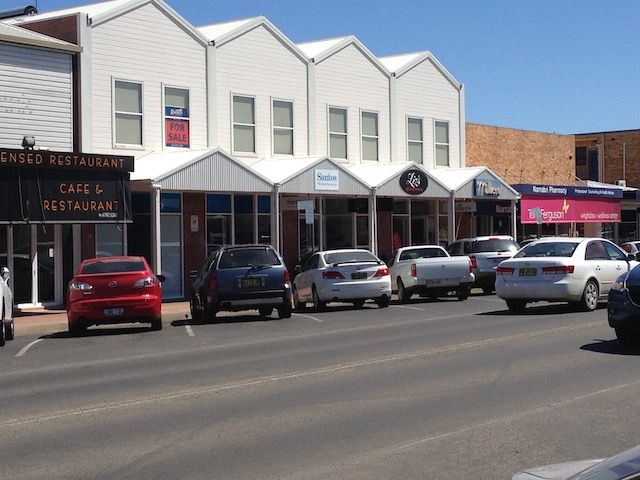 Street view of storefronts with parked cars. White buildings with gabled roofs. — Tamworth Strata Management Services in Narrabri, NSW