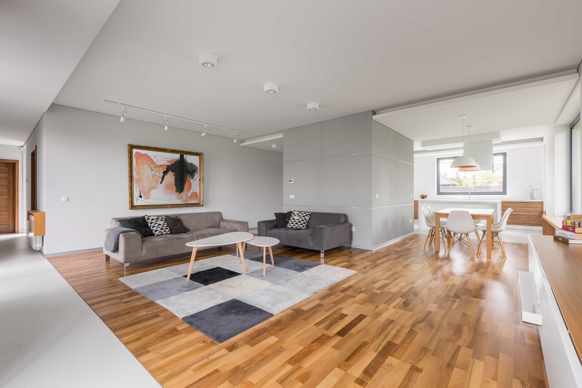 A living room with hardwood floors, a couch, a table, and a rug.