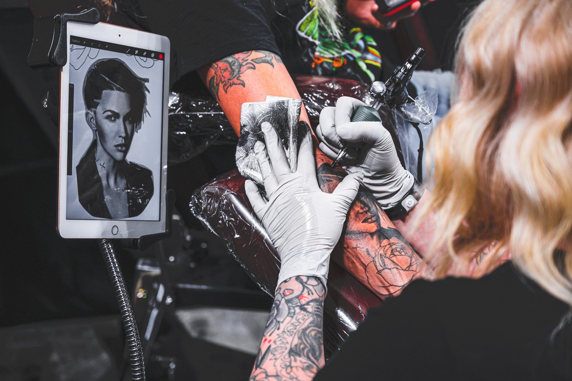 A person is getting a tattoo on their arm.