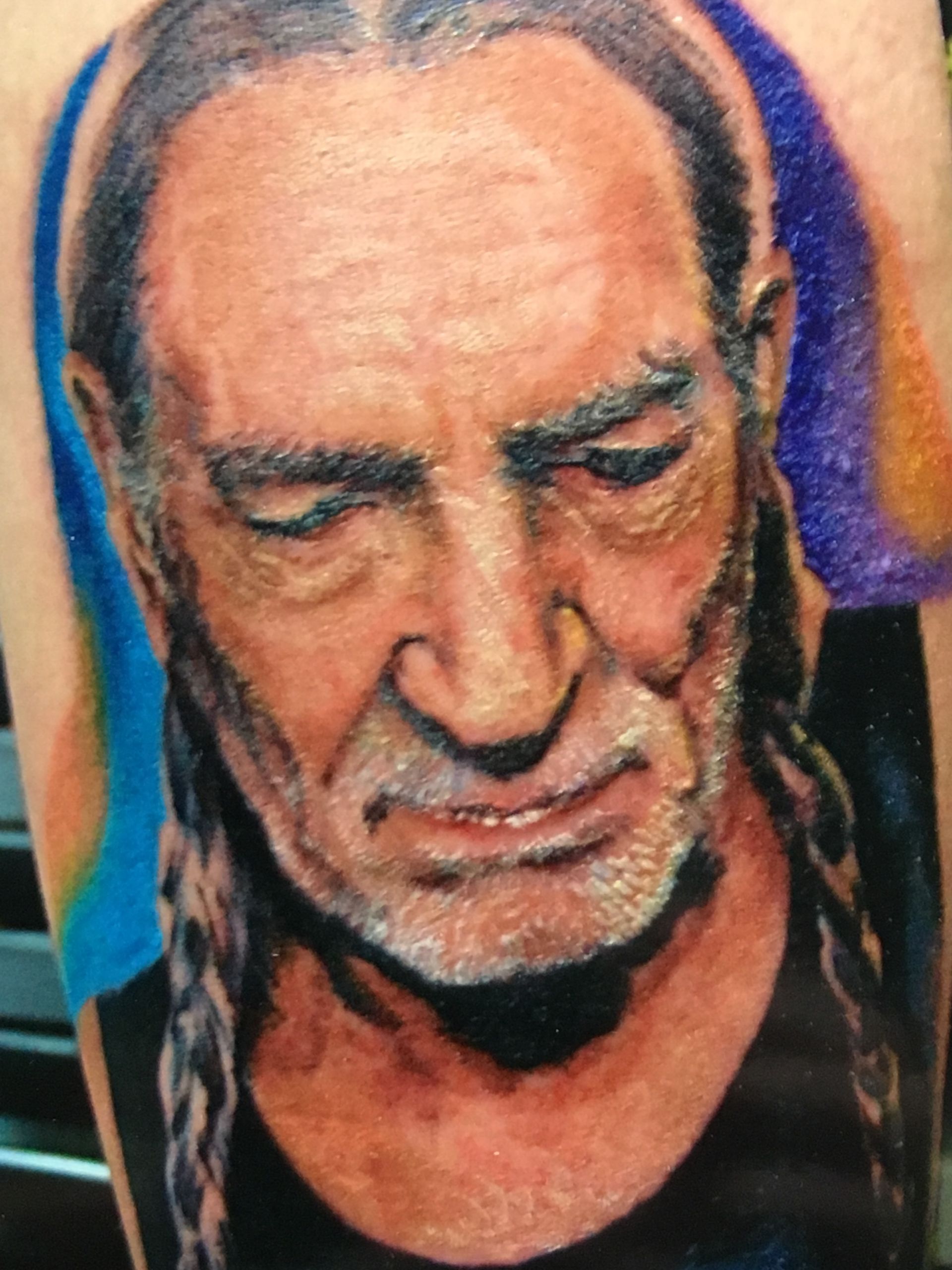 A close up of a tattoo of a man with his eyes closed
