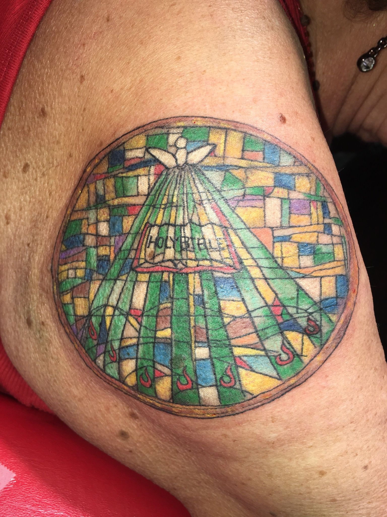 A woman has a stained glass tattoo on her arm.