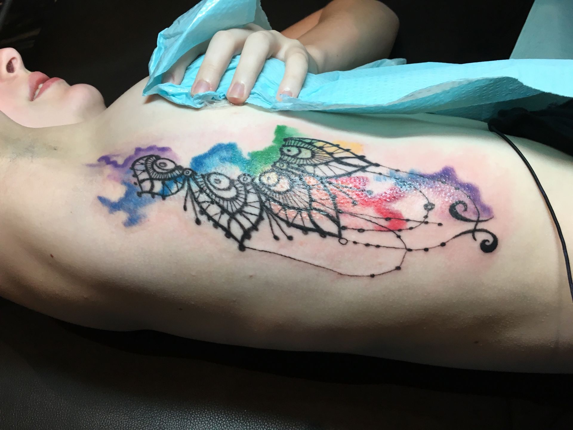 A woman has a colorful tattoo on her side