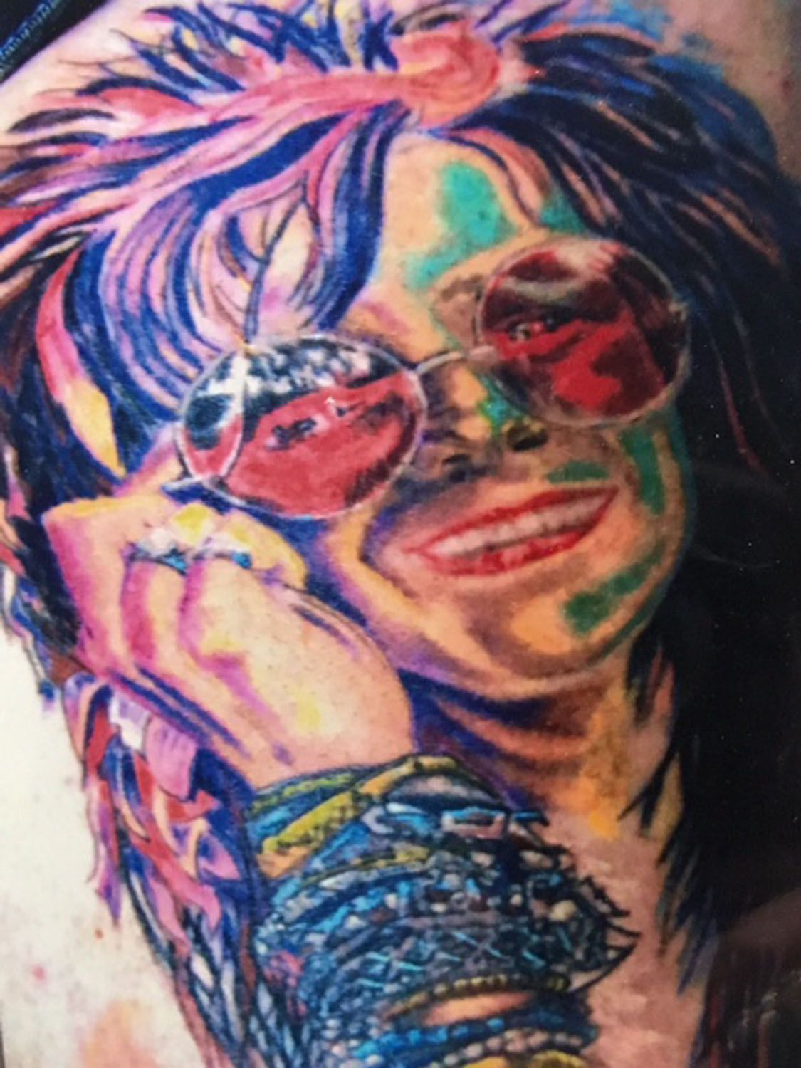 A tattoo of a woman wearing sunglasses and bracelets