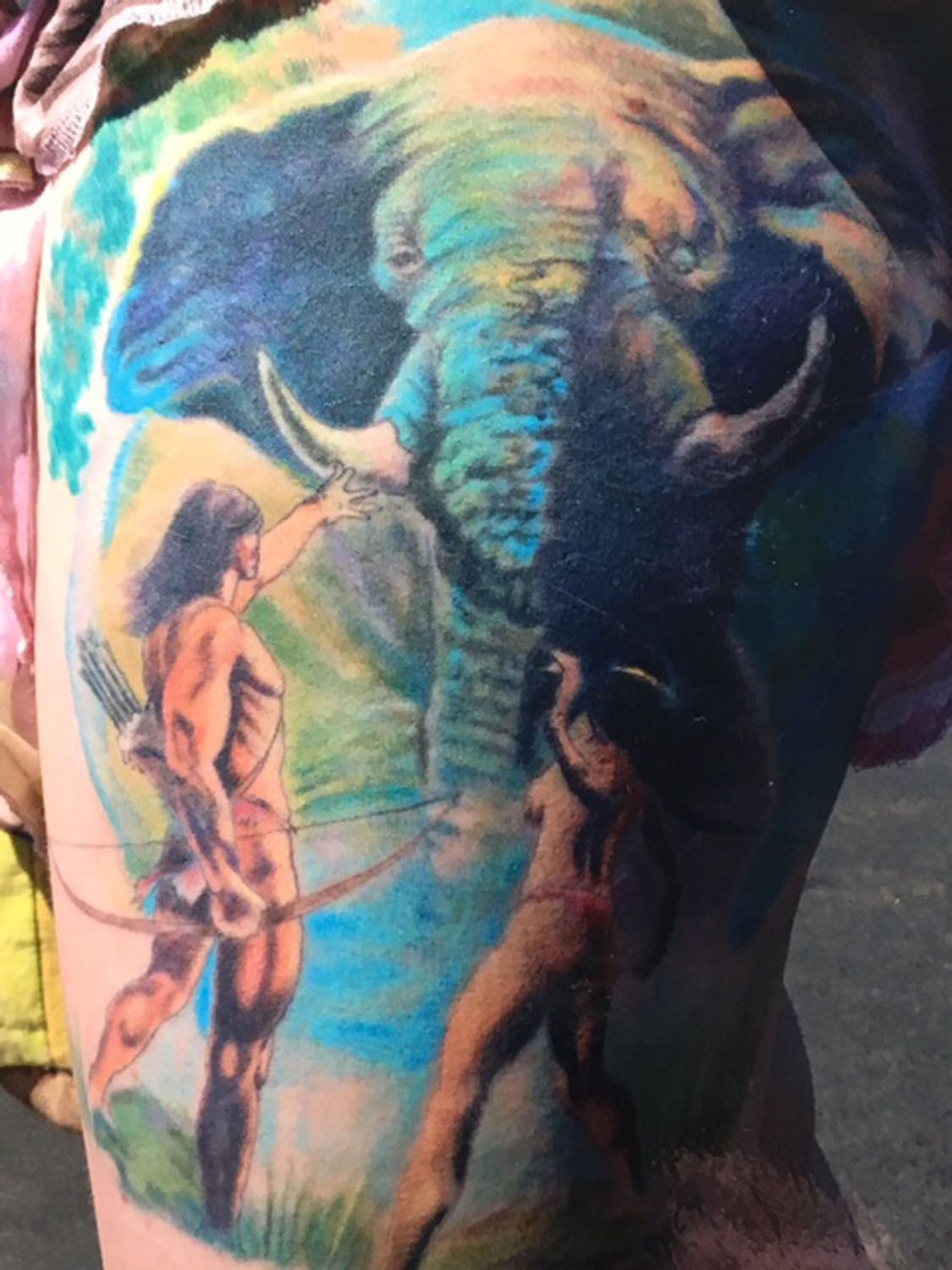 A tattoo of a man and an elephant on a person 's back