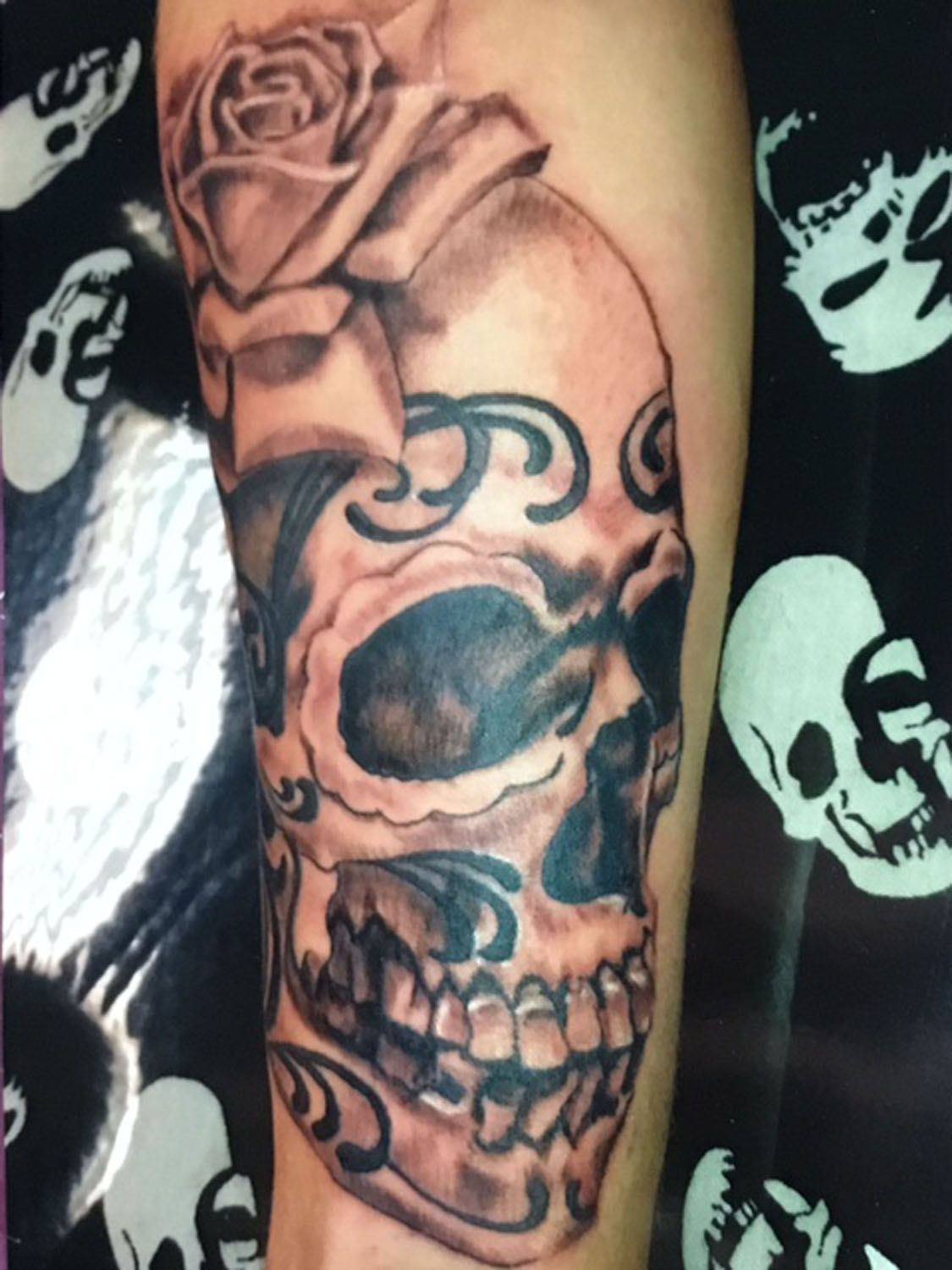 A tattoo of a skull with a rose on it