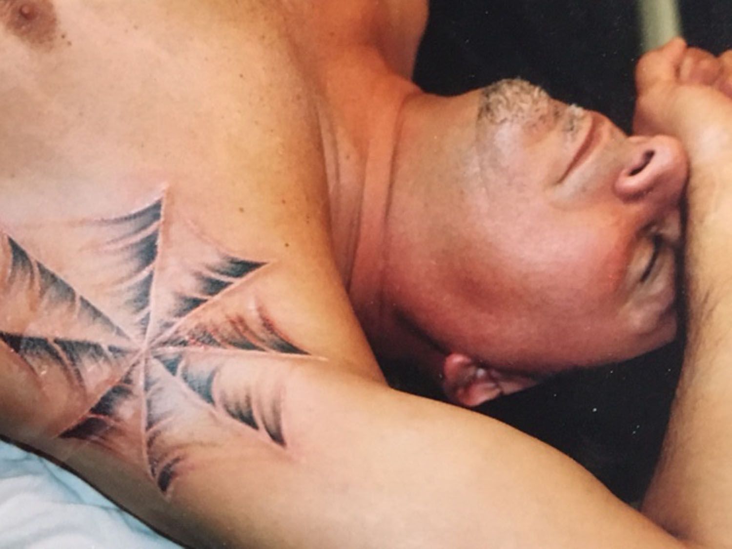 A man has a tattoo of a cross on his arm