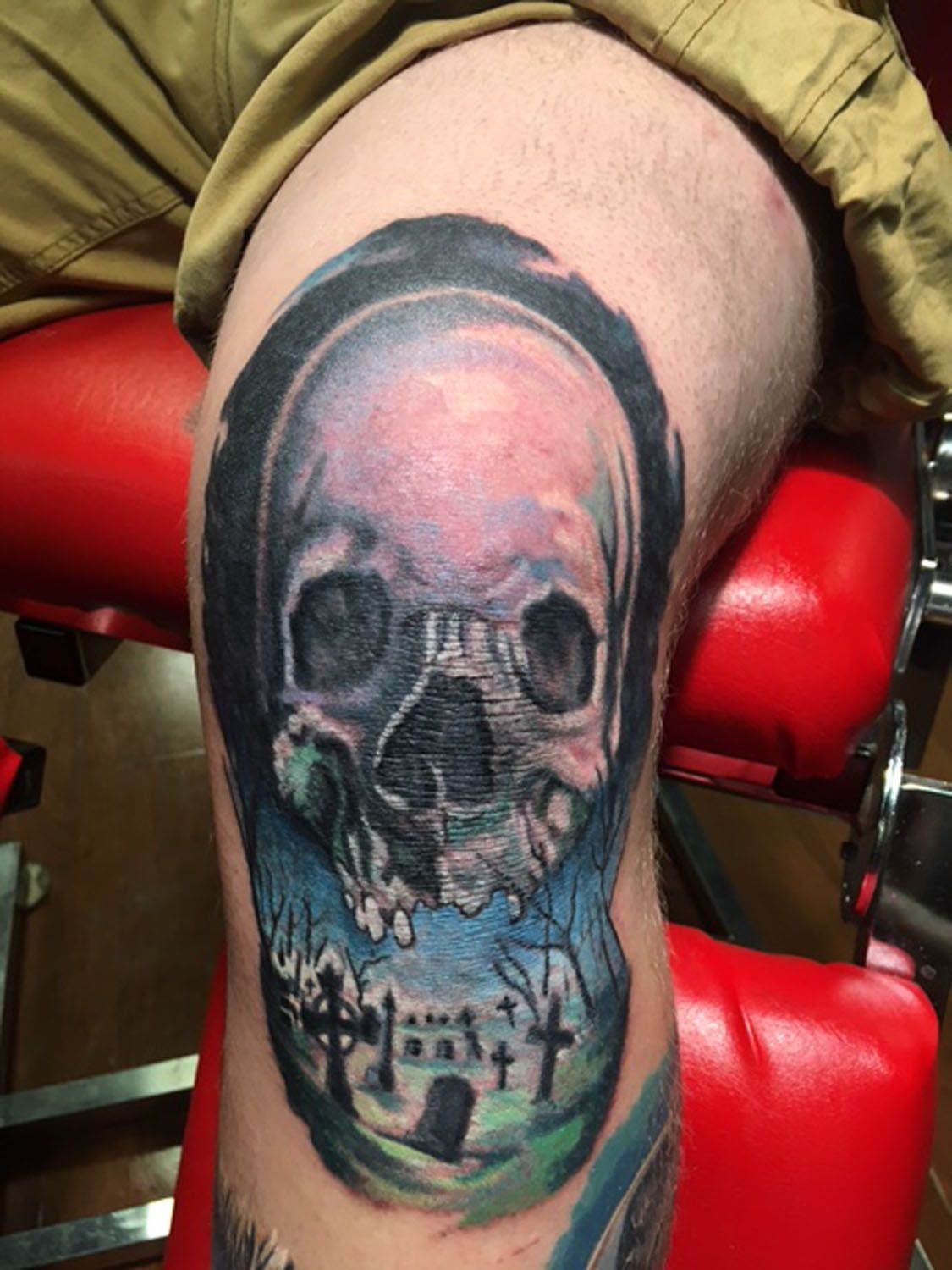 A man has a tattoo of a skull on his knee