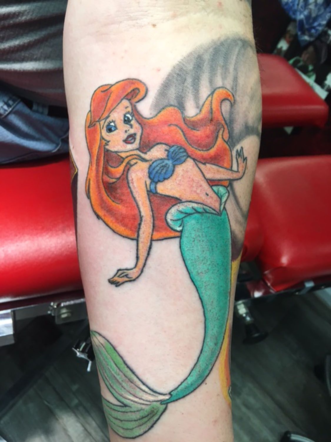 A person has a tattoo of a mermaid on their arm
