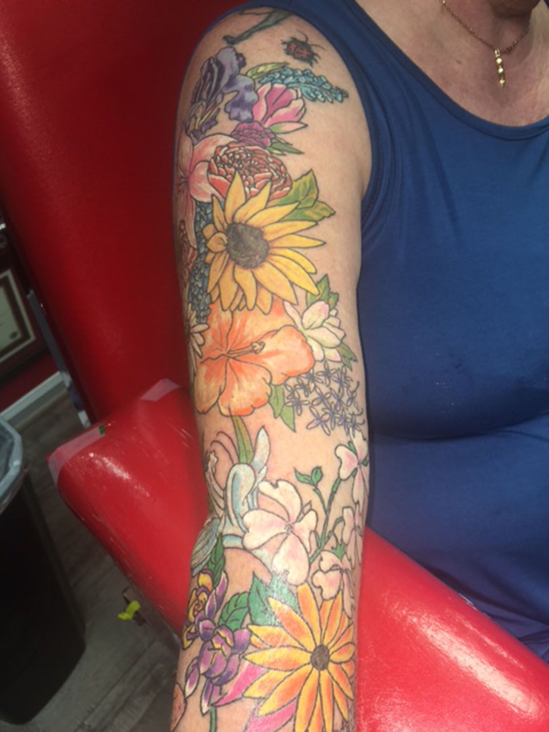 A woman has a tattoo of flowers on her arm.