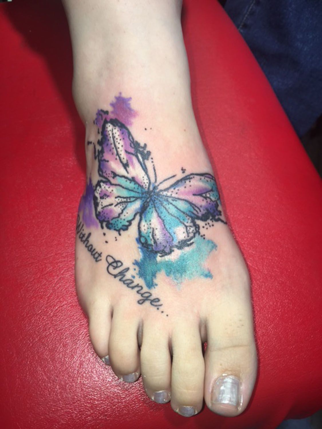 A woman has a tattoo of a butterfly on her foot